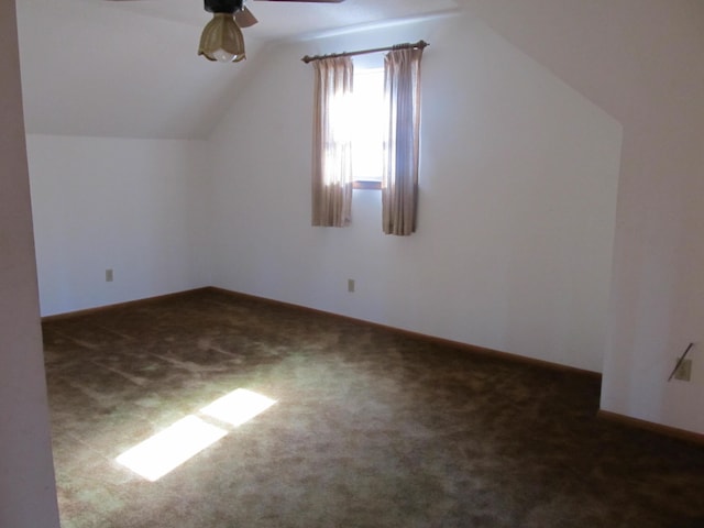 additional living space with ceiling fan, dark carpet, and vaulted ceiling