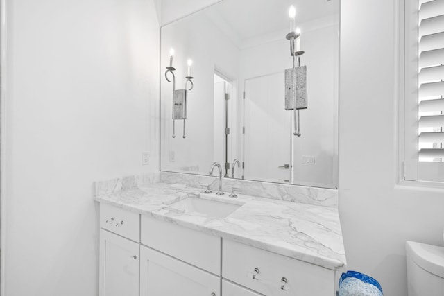 bathroom featuring crown molding, vanity, and toilet