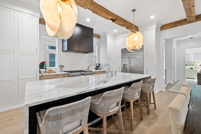 kitchen featuring beam ceiling, white cabinetry, stainless steel appliances, and premium range hood