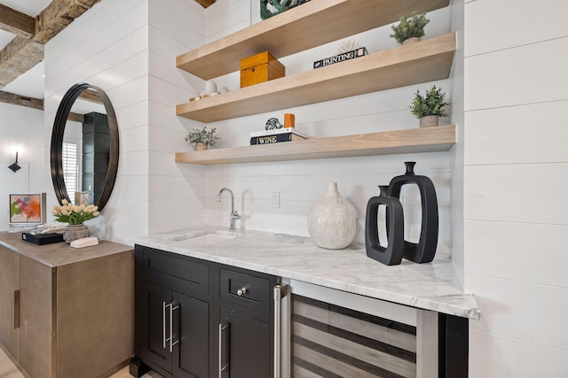 bar with wine cooler, light stone countertops, sink, and decorative backsplash