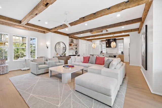 living room featuring beamed ceiling, ceiling fan, and light hardwood / wood-style floors