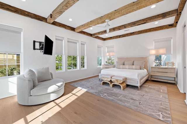 bedroom featuring beamed ceiling and light wood-type flooring