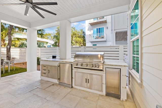 view of patio featuring an outdoor kitchen, area for grilling, and ceiling fan