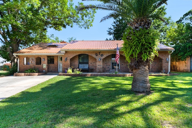 ranch-style home featuring covered porch and a front yard