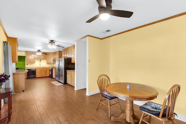 dining area featuring hardwood / wood-style flooring, ceiling fan, ornamental molding, and sink