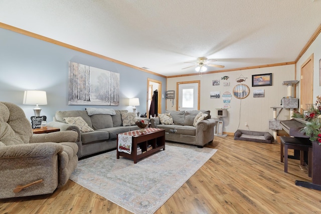 living room with hardwood / wood-style flooring, ceiling fan, crown molding, and a textured ceiling