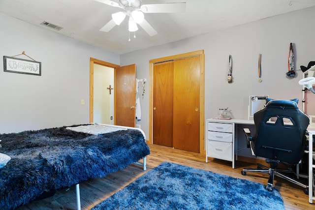 bedroom with hardwood / wood-style flooring, ceiling fan, and a closet