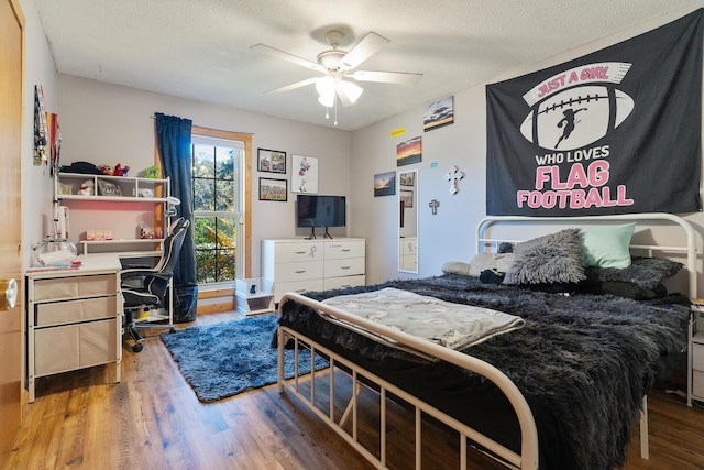 bedroom featuring hardwood / wood-style flooring, ceiling fan, and a textured ceiling