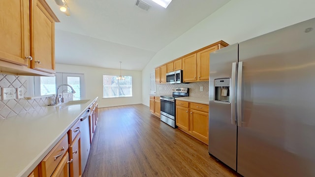 8679 High School Blvd, Navarre, FL 32566 - kitchen with visible vents, dark wood-type flooring, vaulted ceiling, appliances with stainless steel finishes, and a sink
