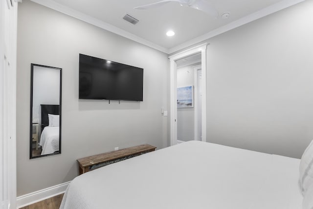 bedroom featuring hardwood / wood-style flooring, ceiling fan, and crown molding