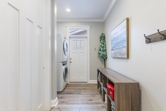 laundry room featuring crown molding, light hardwood / wood-style flooring, and stacked washer and clothes dryer