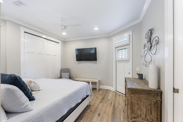 bedroom featuring a closet, light hardwood / wood-style floors, ceiling fan, and crown molding