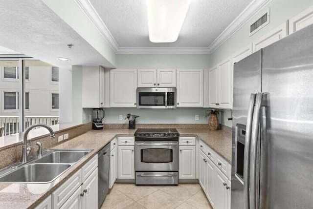 kitchen featuring white cabinets, appliances with stainless steel finishes, a textured ceiling, and sink