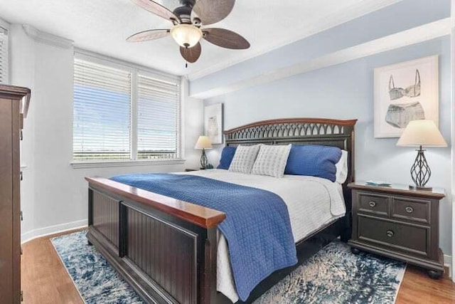 bedroom with ceiling fan, light hardwood / wood-style floors, and ornamental molding