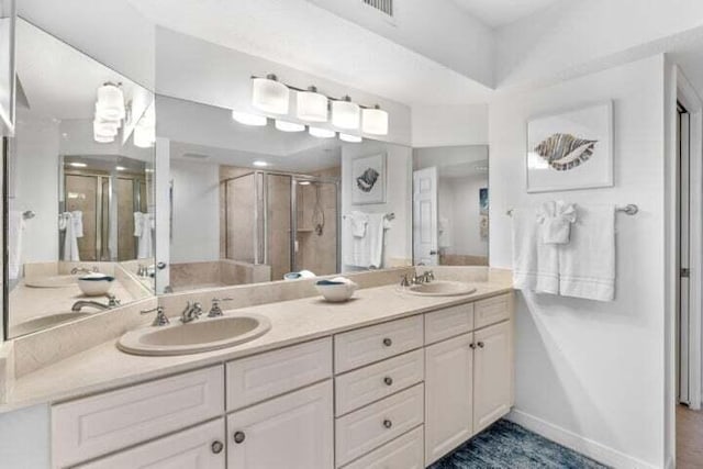 bathroom featuring a shower with door and vanity