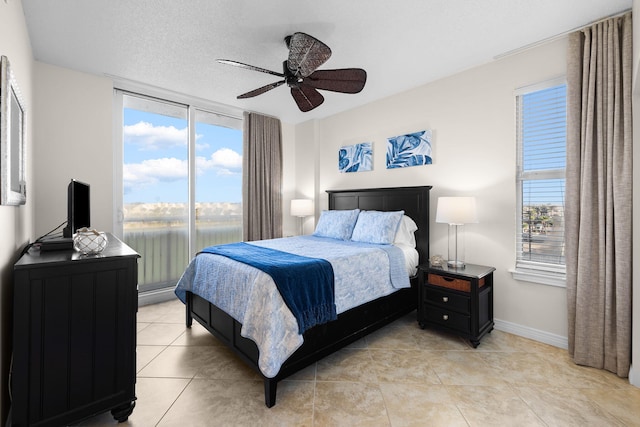 tiled bedroom with ceiling fan and a textured ceiling