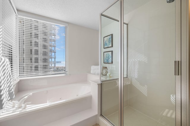 bathroom with a textured ceiling, toilet, and independent shower and bath