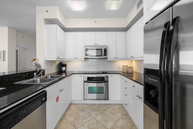 kitchen with white cabinets, sink, light tile patterned floors, appliances with stainless steel finishes, and tasteful backsplash