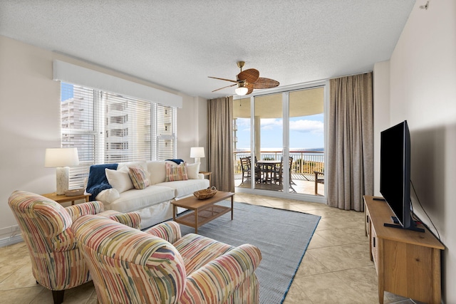 8501 Gulf Blvd Unit 3A, Navarre, FL 32566 - living area featuring a ceiling fan, light tile patterned flooring, a wall of windows, and a textured ceiling