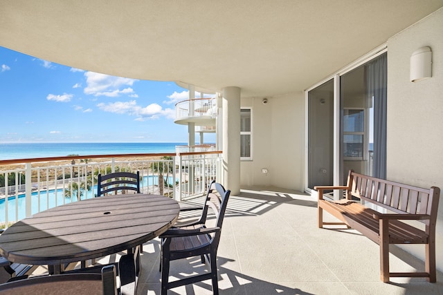 balcony featuring a water view and a beach view