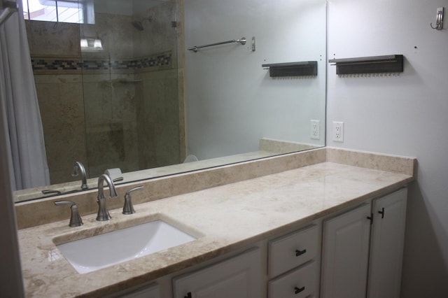 bathroom with tiled shower and vanity