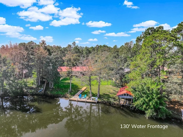 dock area featuring a wooded view and a water view