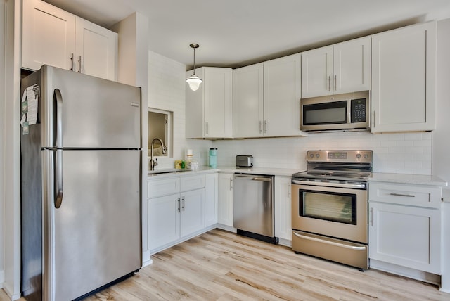 kitchen featuring appliances with stainless steel finishes, white cabinetry, and sink