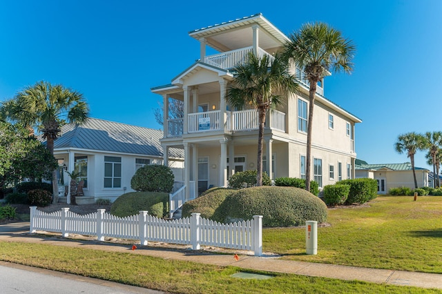 view of front of home featuring a front yard and a balcony