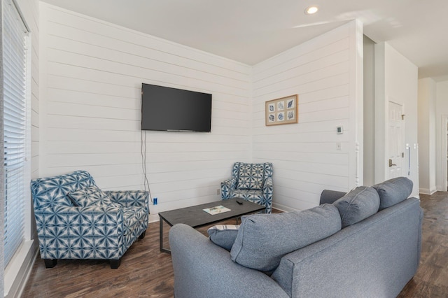 living room with dark hardwood / wood-style flooring and wooden walls