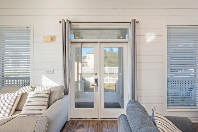 doorway with french doors, dark hardwood / wood-style flooring, and wood walls