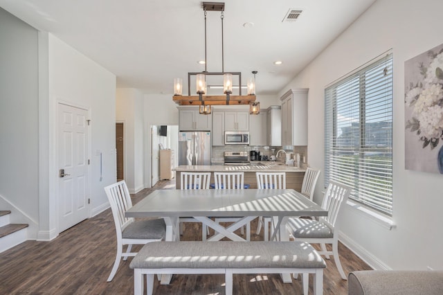 dining space featuring sink, dark hardwood / wood-style floors, and a notable chandelier