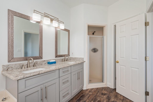 bathroom featuring vanity, hardwood / wood-style flooring, and a shower with door