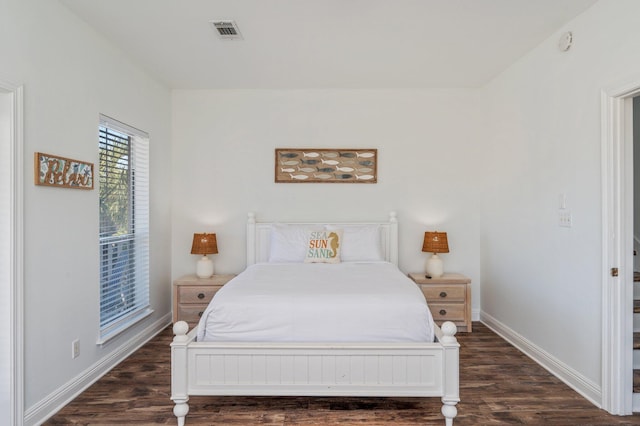 bedroom with dark hardwood / wood-style floors