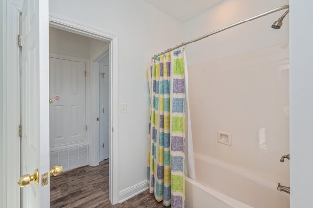 bathroom with shower / bathtub combination with curtain and wood-type flooring