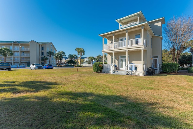 back of property featuring covered porch, a yard, a balcony, and cooling unit