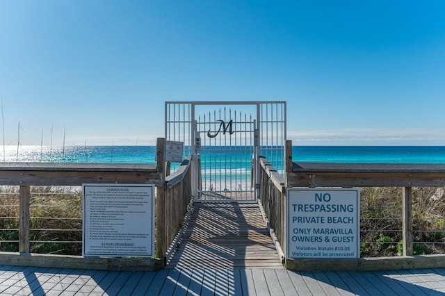 wooden terrace featuring a view of the beach and a water view