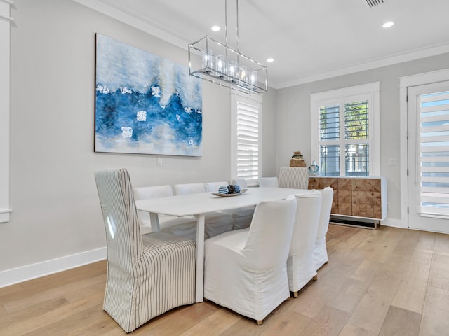 dining space with a chandelier, crown molding, and light hardwood / wood-style flooring