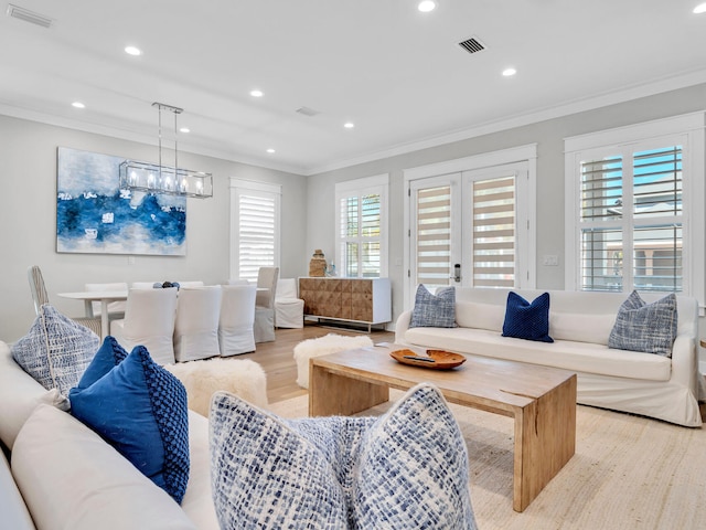 living room with light hardwood / wood-style floors and ornamental molding