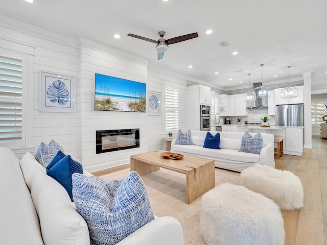 115 Woody Wagon Way, Inlet Beach, FL 32461 - living area with light wood-style flooring, crown molding, a glass covered fireplace, recessed lighting, and a ceiling fan