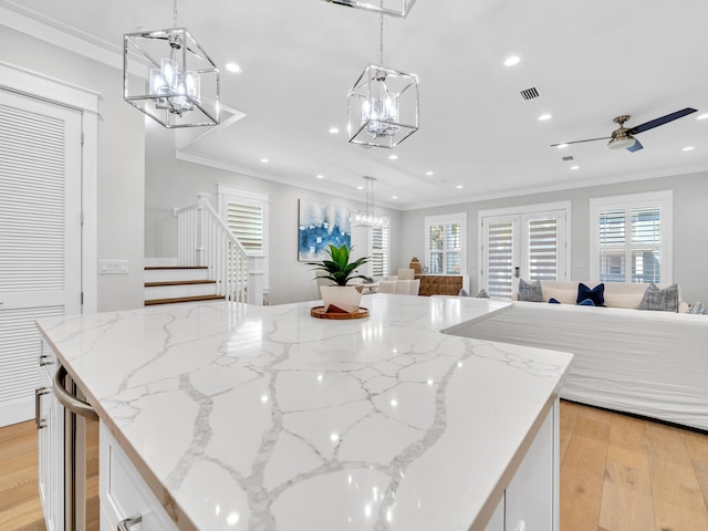 115 Woody Wagon Way, Inlet Beach, FL 32461 - kitchen with ornamental molding, open floor plan, white cabinetry, light wood-style floors, and a chandelier
