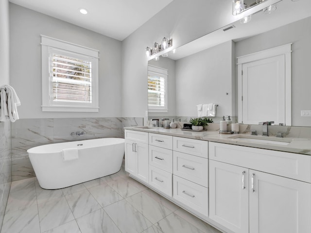 115 Woody Wagon Way, Inlet Beach, FL 32461 - full bath featuring double vanity, marble look tiles, a soaking tub, a wainscoted wall, and recessed lighting