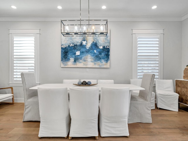 dining room featuring light hardwood / wood-style flooring, ornamental molding, and a notable chandelier