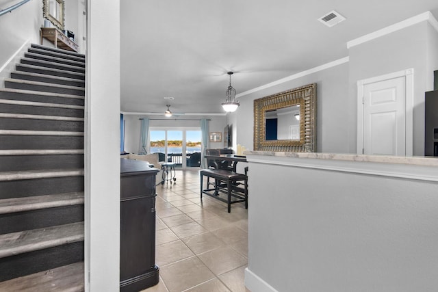 interior space featuring tile patterned floors, crown molding, and ceiling fan