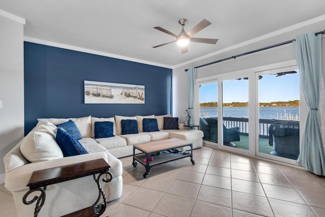 living room featuring ceiling fan, a water view, light tile patterned floors, and ornamental molding