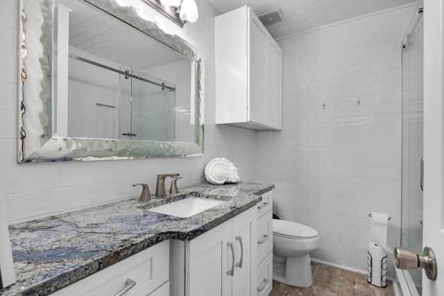 bathroom featuring vanity, toilet, walk in shower, tile walls, and wood-type flooring