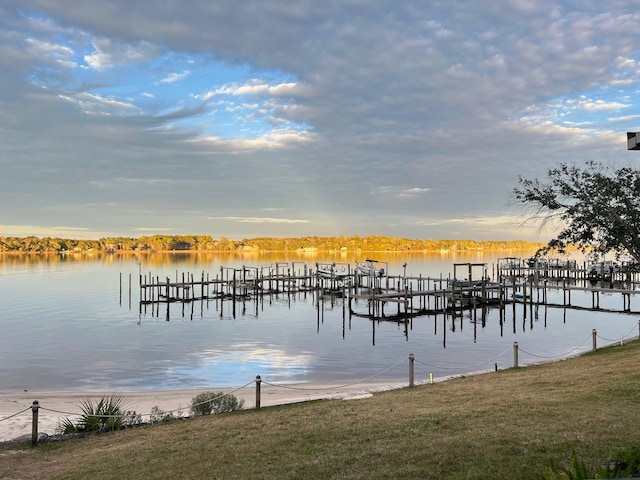 view of dock featuring a water view and a yard