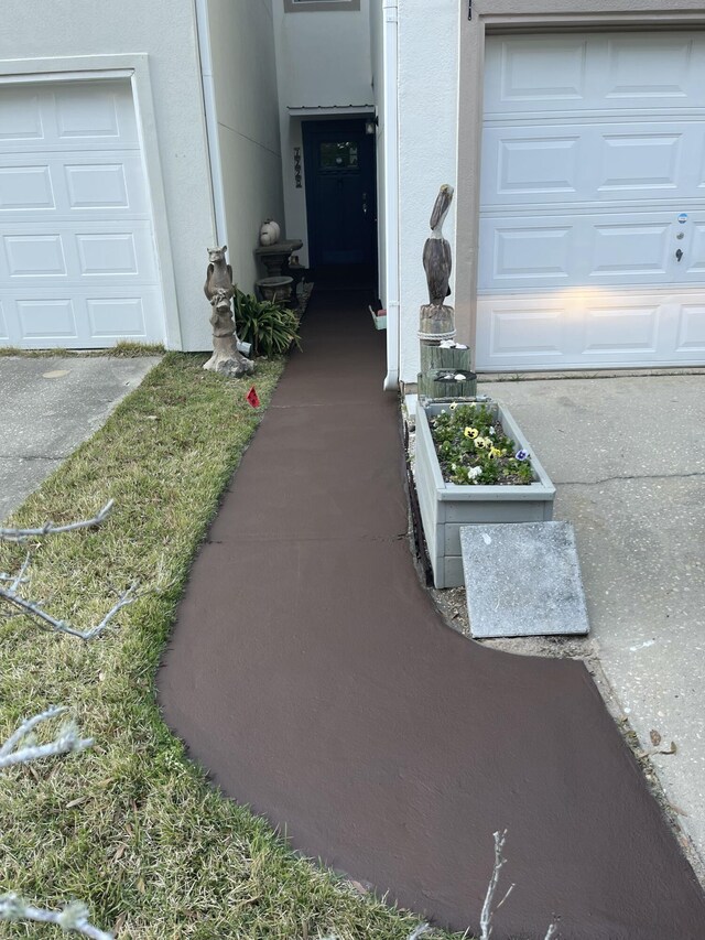 view of exterior entry featuring a garage and stucco siding