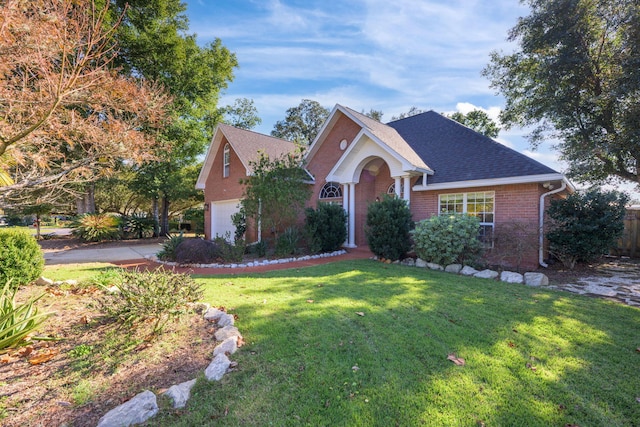 view of front facade with brick siding, a shingled roof, a front lawn, fence, and a garage