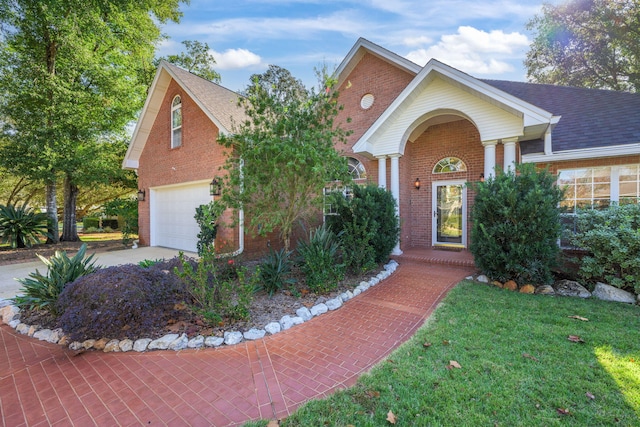 view of front of property with brick siding, driveway, and a shingled roof