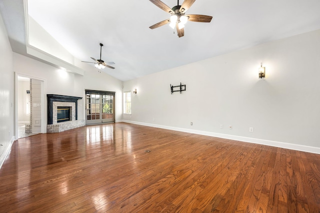 unfurnished living room with baseboards, a brick fireplace, wood finished floors, and a ceiling fan